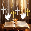 A decorative set featuring silver and gold crosses and white doves suspended above an open book.