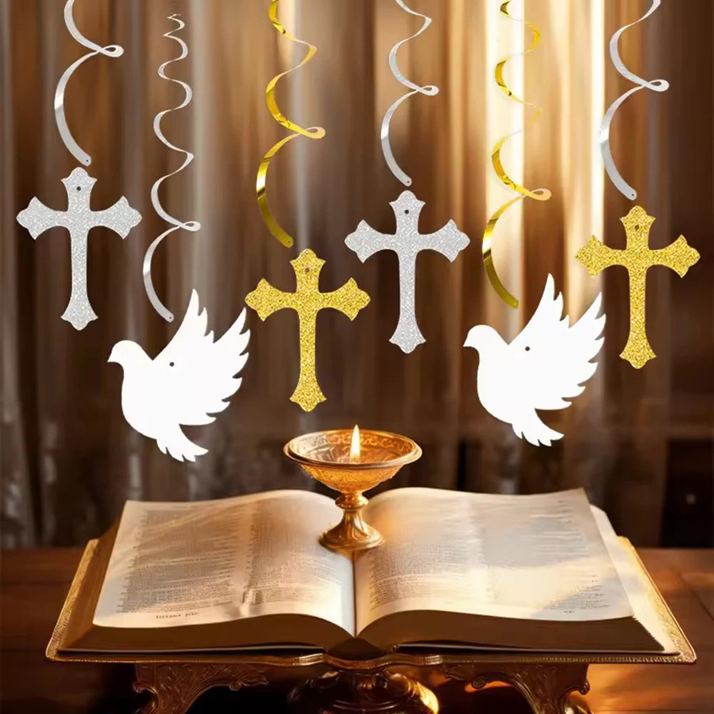 A decorative set featuring silver and gold crosses and white doves suspended above an open book.