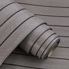 Roll of self-adhesive 3D wood grain wall panels in gray with black accent lines