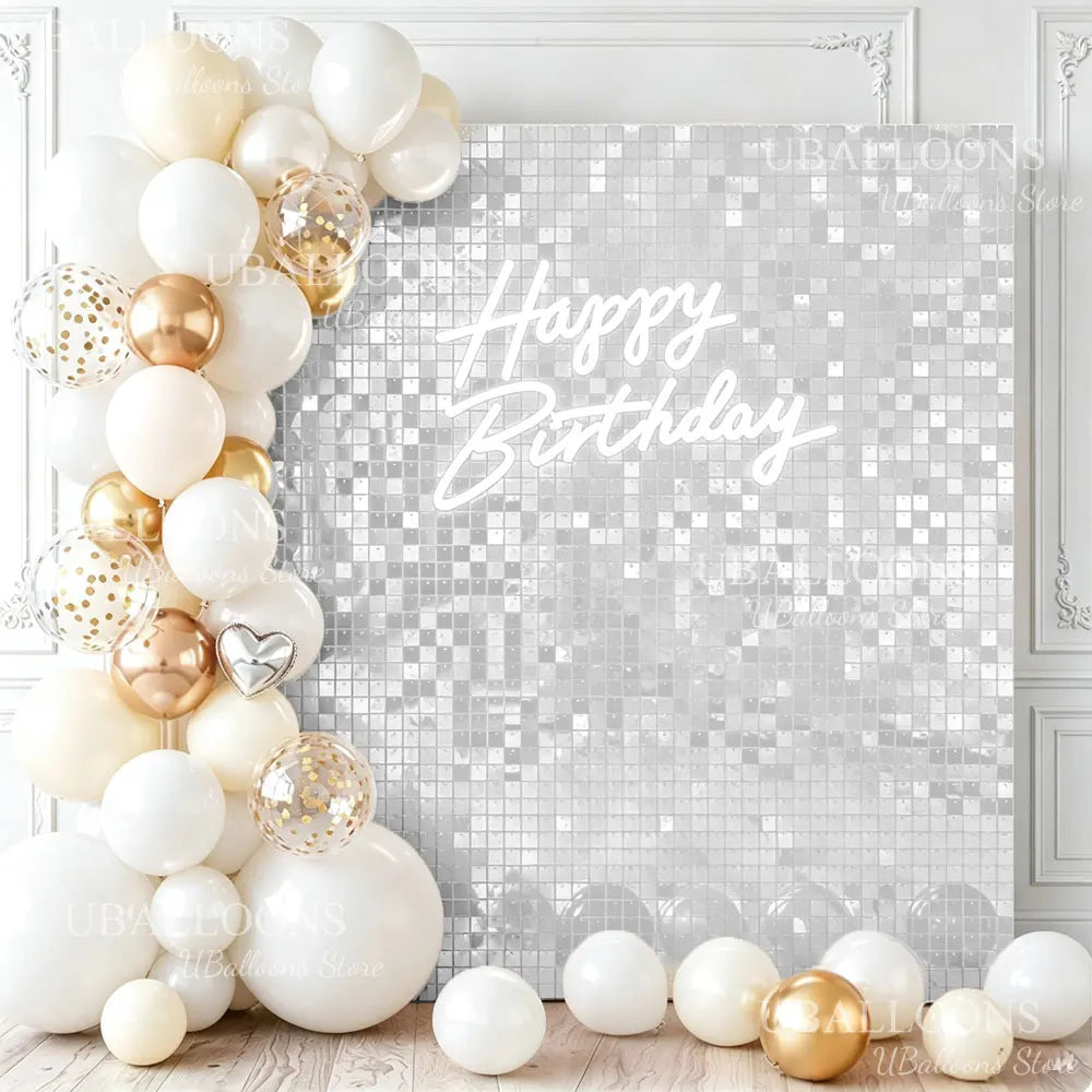 A white and gold sequin wall backdrop featuring a Happy Birthday message on a silver glitter background.