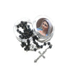 A set of black wood beads and a crucifix necklace displayed in glass jars.