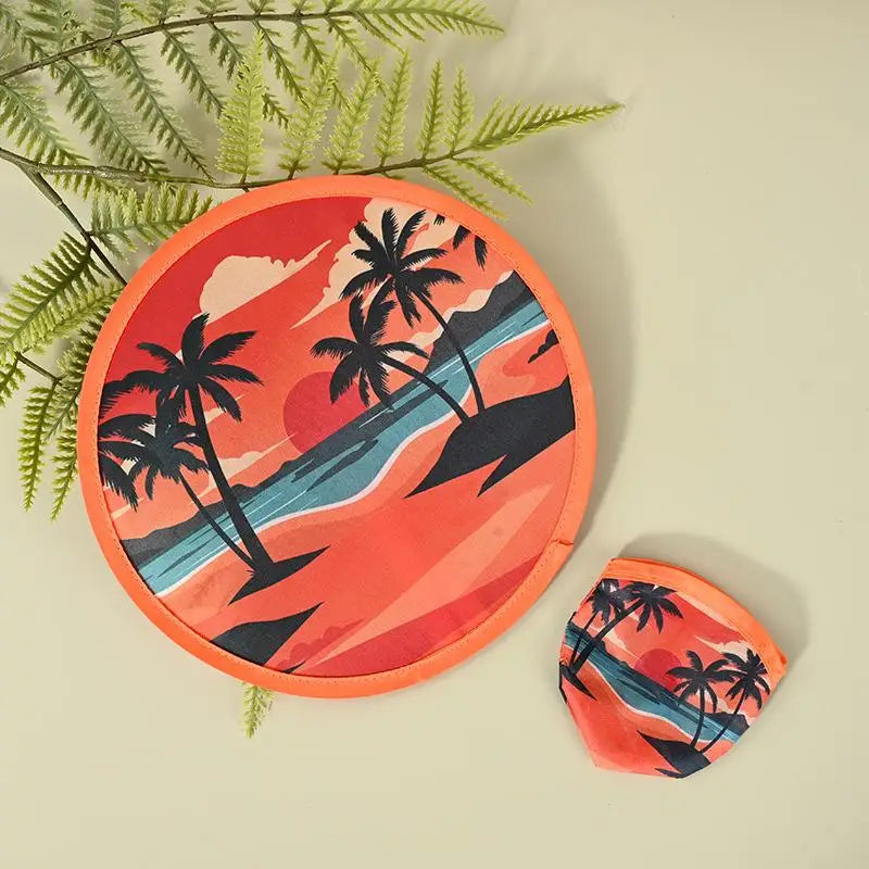 A round orange cooling fan featuring a tropical sunset design with silhouetted palm trees and mountains.