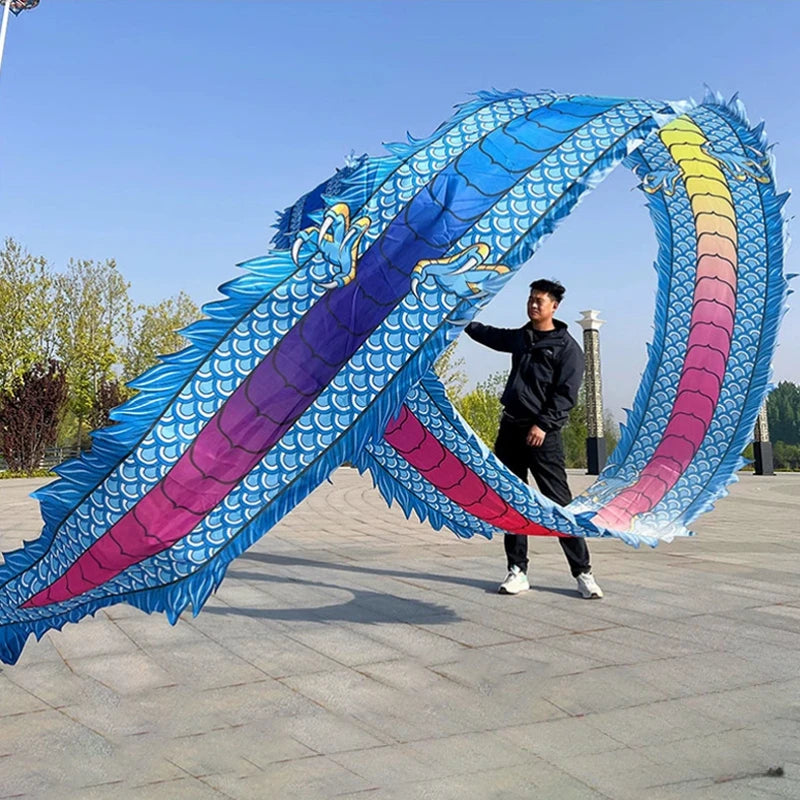 Una persona realiza una danza de dragón con un gran accesorio de tela colorido en forma de dragón, con escamas azules y morad