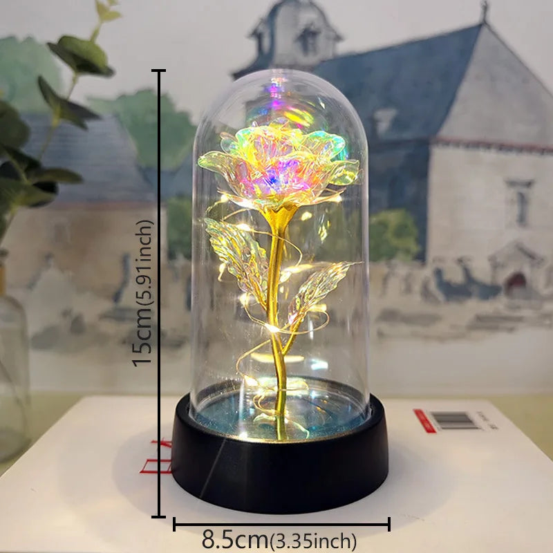 A glass dome containing an eternal rose with a glowing yellow LED light, displayed on a black base.
