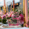 A heart-shaped glass plaque with pink lettering for a coworker friendship gift surrounded by flowers and candles.