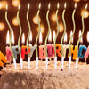 Birthday candles shaped like letters spelling HAPPY BIRTHDAY arranged on a light-colored cake