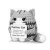 A handmade knitted plush cat toy with gray and white fur and a sign that reads You're Purr-fect