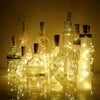 Ten glass wine bottles with LED lights inside, set against a dark background.