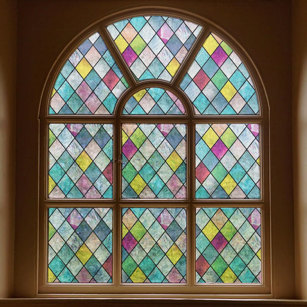 A close-up of a arched stained glass window featuring multicolored diamond patterns.