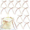 A white cake decorated with pale yellow frosting and adorned with elegant ribbon bow toppers.