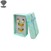Caja de regalo de joyería verde menta claro con la tapa abierta, mostrando dos piezas decorativas de oro y dos piezas de perl