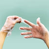 A person wearing clear disposable safety gloves is demonstrating or handling a white plastic strip.