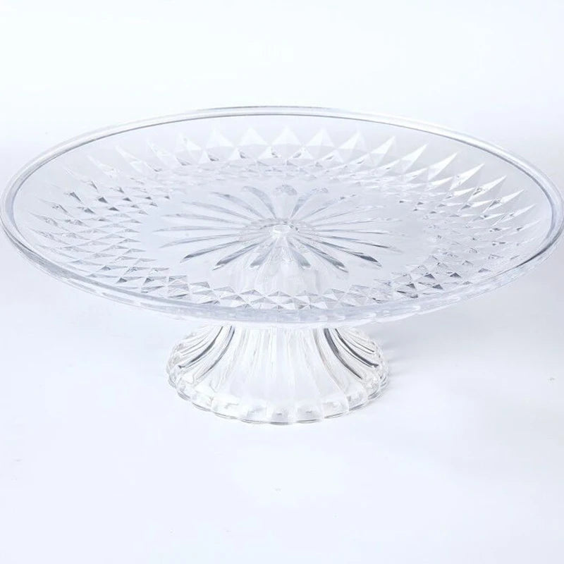 Clear acrylic serving plate with a decorative pattern on a pedestal base.