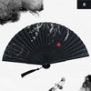 A black vintage silk bamboo folding hand fan with delicate white floral designs.