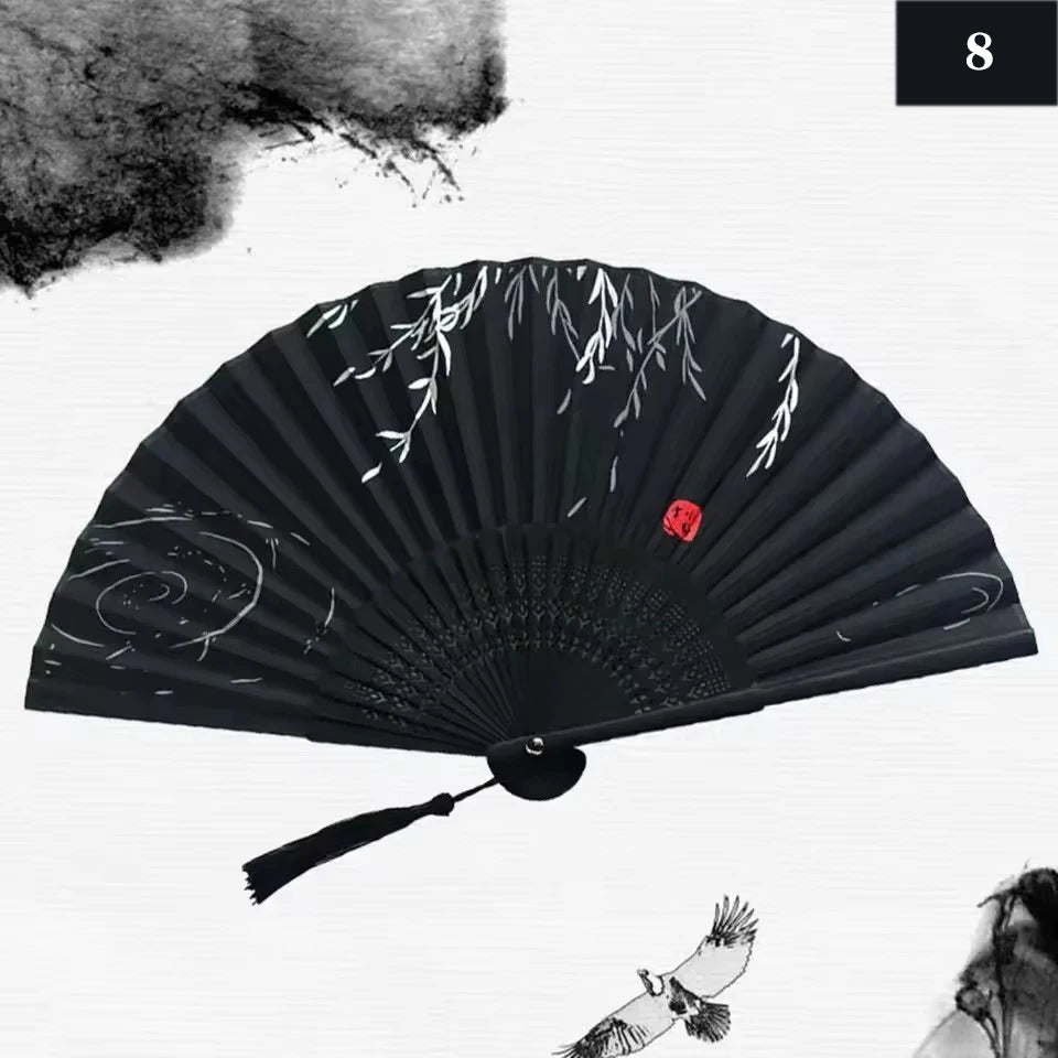 A black vintage silk bamboo folding hand fan with delicate white floral designs.
