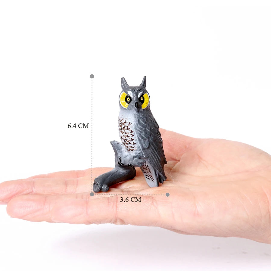 A realistic figurine set of an owl, vulture, and bald eagle displayed on a human hand.