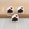 A set of festive Christmas resin decor featuring miniature houses with snow and greenery.