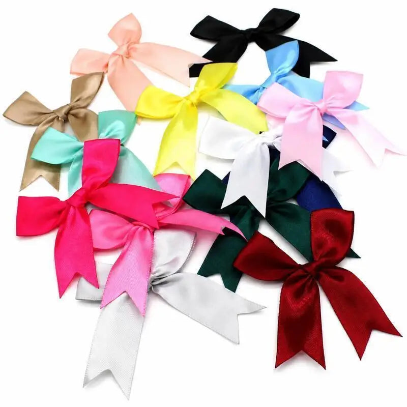 A collection of elegant satin ribbon bows in various colors including pink, yellow, black, and green.