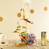 A clear plastic bag filled with gold curling ribbon rolls and colorful glitter, set on a textured surface.