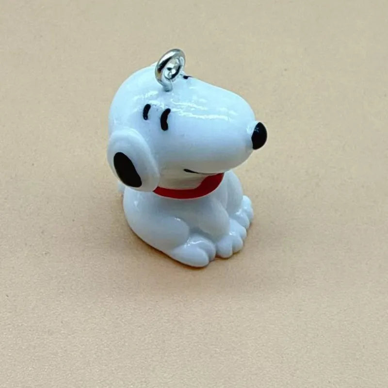 A white ceramic dog pendant with black eyes and a red collar, designed for jewelry making.