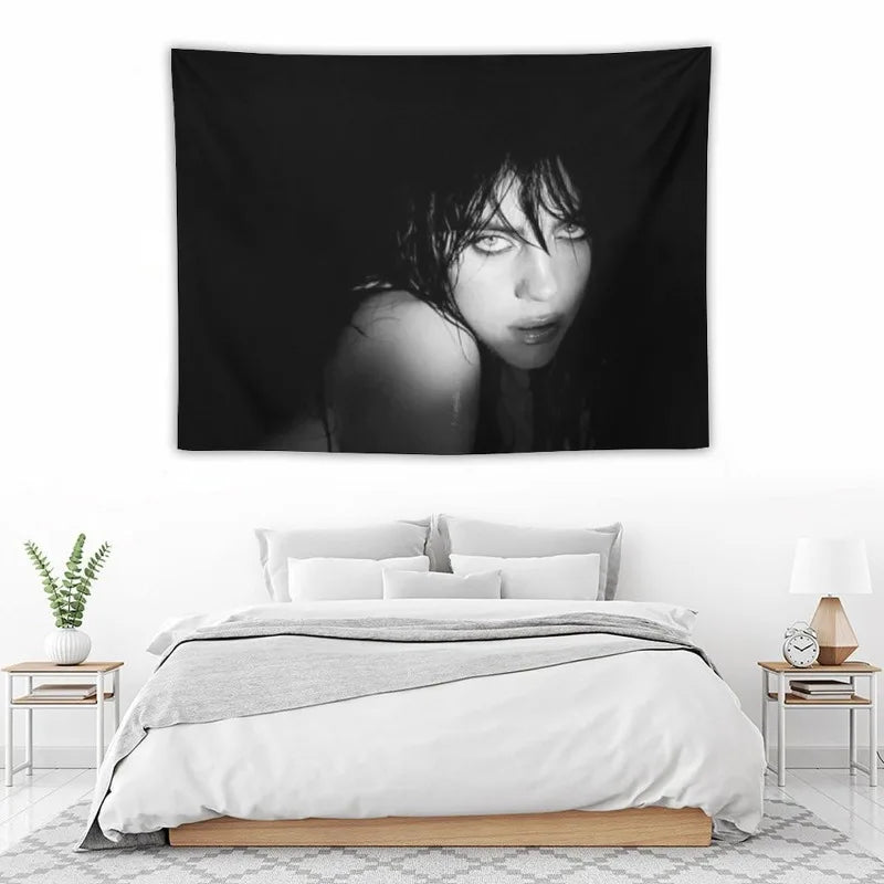 A black and white portrait of Billie Eilish with dark hair looking intensely at the camera.