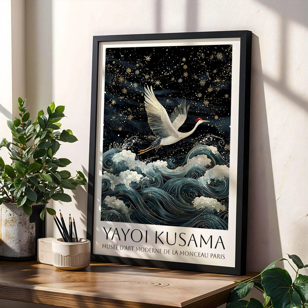 Black framed canvas art featuring a white crane in flight against a dark, starry night sky and blue waves.