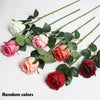 A bouquet of artificial roses in various shades of pink and red, including white and coral tones.