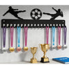 A black metal display rack with 20 hooks for wall mounting, featuring various colored medals and a soccer ball silhouette.