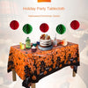 Orange Halloween tablecloth featuring a black print of pumpkins, spider webs, and bats, set for a party.