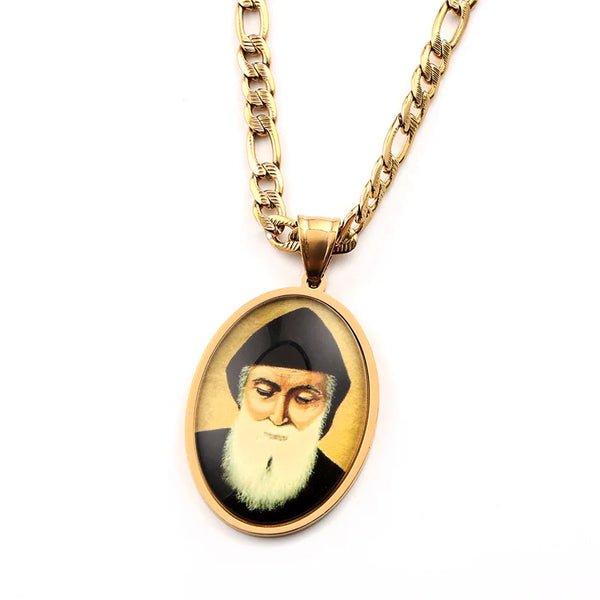 A gold-toned chain necklace with an oval pendant featuring a portrait of Saint Charbel.