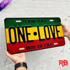 A black metal wall sign with yellow and red stripes featuring the text ONE LOVE and WAY OF LIFE.