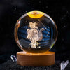 A clear crystal ball with a dark background and a silhouette of a person engraved inside.