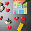 A collection of red heart-shaped fridge magnets and a colorful game card featuring a yellow star.