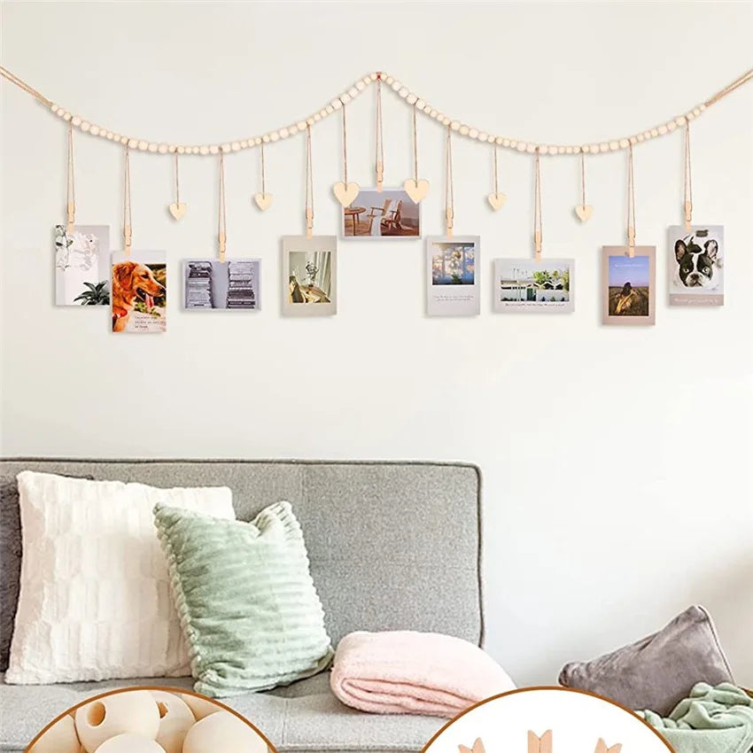 A photo display garland featuring small framed photos suspended from a string against a white wall.