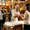A woman is handing mini baptism rosary favors with crosses to another guest in a church setting.