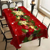 Festive red Christmas tablecloth featuring green foliage and gold flowers on a dining table.