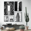 A gallery wall featuring black and white photographs of modern architecture, including skyscrapers and bridges.