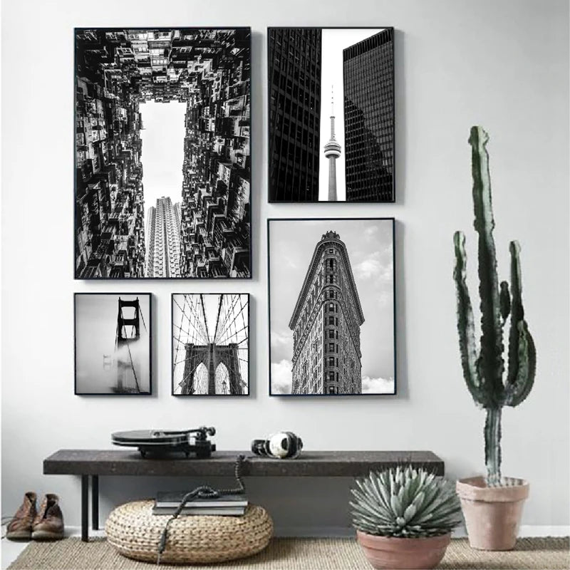 A gallery wall featuring black and white photographs of modern architecture, including skyscrapers and bridges.