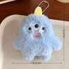 A light blue fuzzy plush monster with large eyes and a yellow cone on top