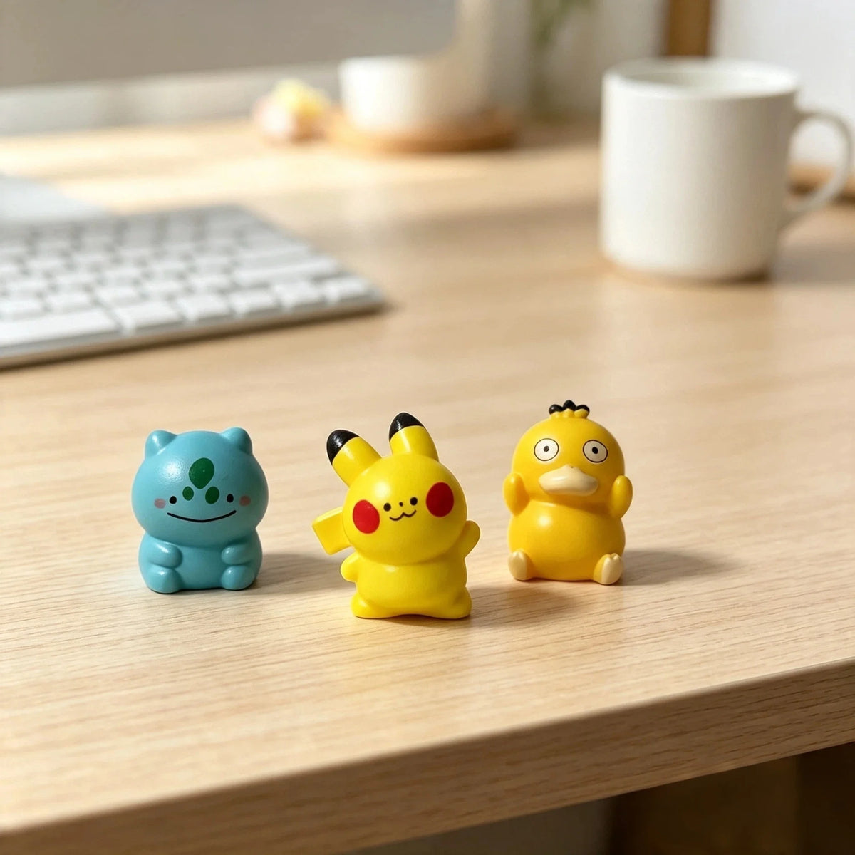 A set of three yellow and blue kawaii anime fantasy creature mini figurines displayed on a wooden table.