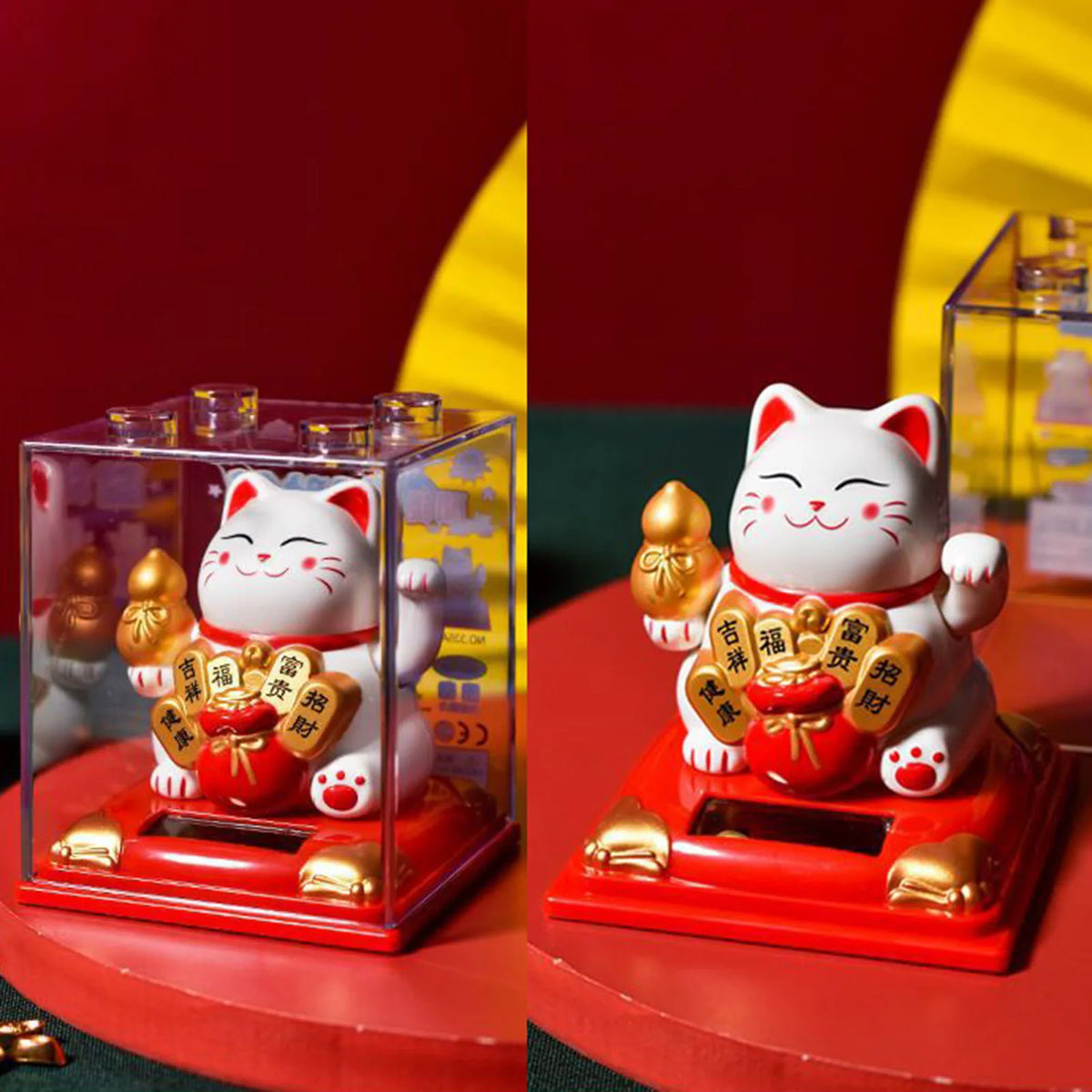 A red solar-powered figurine of a white cat with gold accents, sitting on a red base.