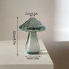 Vase décoratif en verre transparent à forme de champignon avec un chapeau texturé et un corps effilé, sur fond blanc.