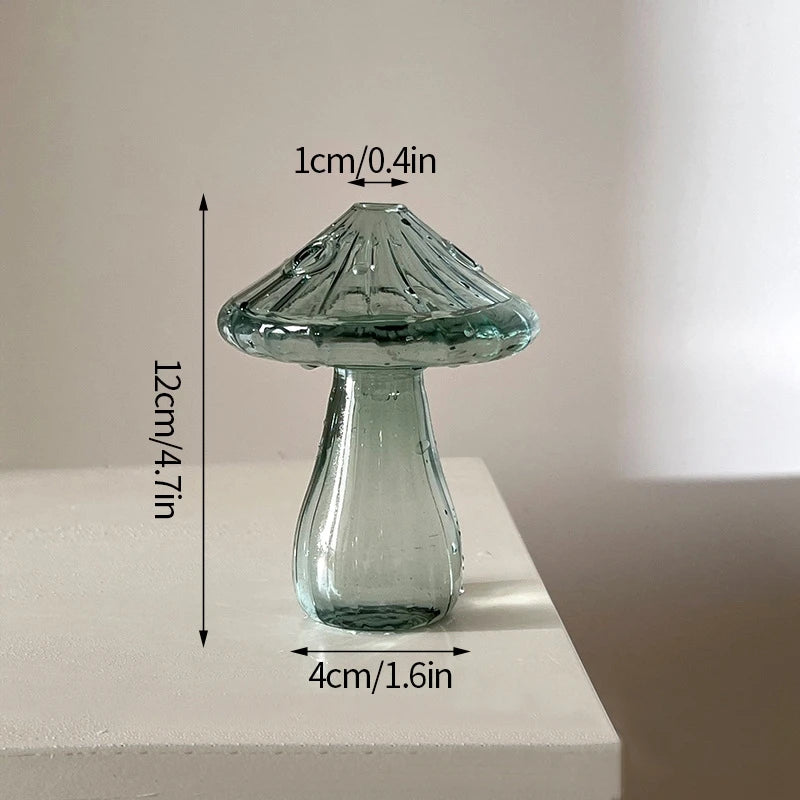 Vase décoratif en verre transparent à forme de champignon avec un chapeau texturé et un corps effilé, sur fond blanc.