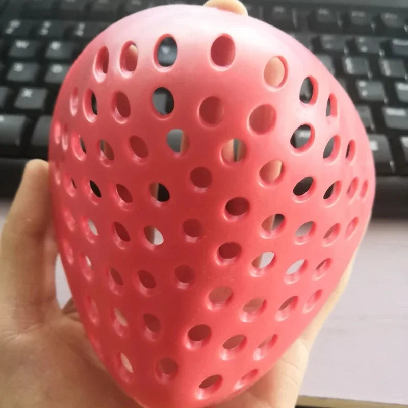 A hand holds a pink, perforated silicone mask designed as a realistic horror animal for Halloween costumes.
