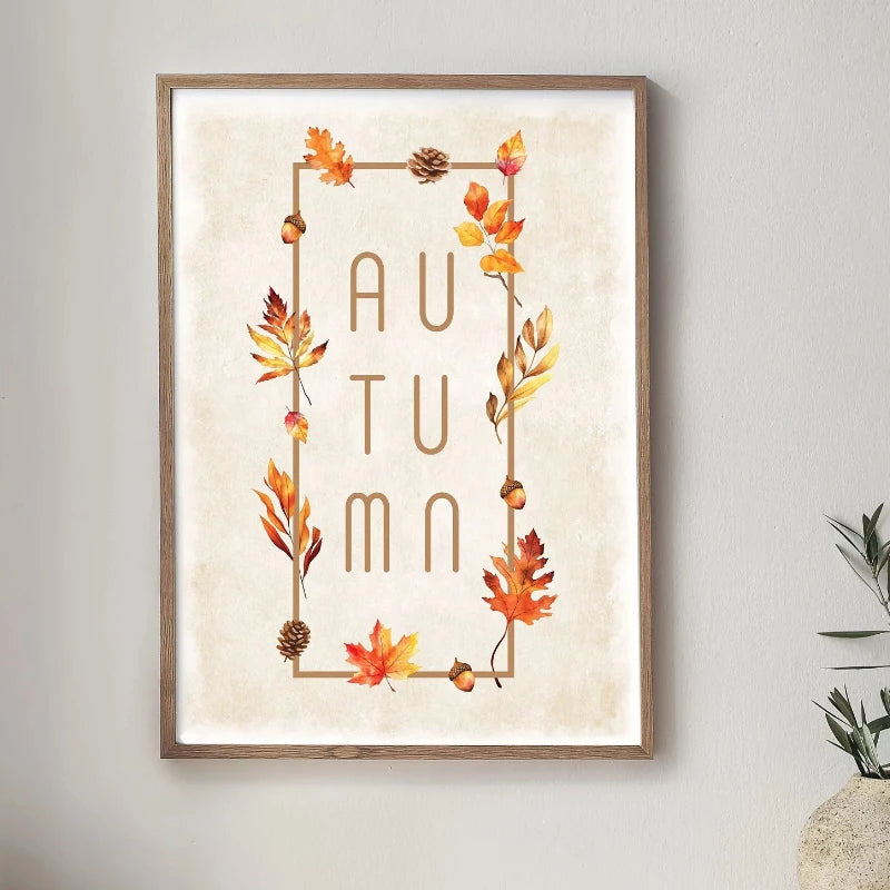 Wall art featuring the word AUTUMN decorated with watercolor autumn leaves and pinecones in a gold frame.