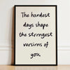A framed black and white motivational quote print on a light background with handwritten text.