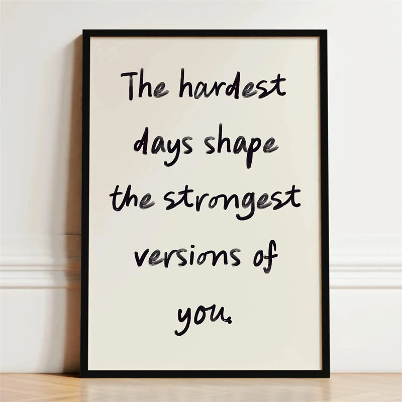 A framed black and white motivational quote print on a light background with handwritten text.