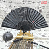An elegant vintage Chinese folding hand fan displayed on a wooden stand with bamboo elements.