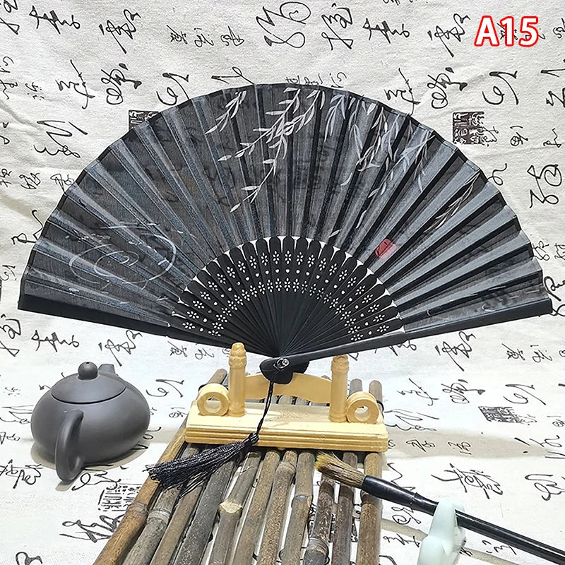 An elegant vintage Chinese folding hand fan displayed on a wooden stand with bamboo elements.