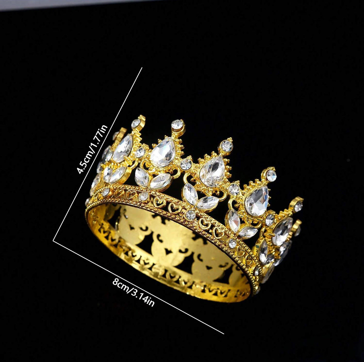 A gold-toned crystal rhinestone crown ring displayed against a black background.